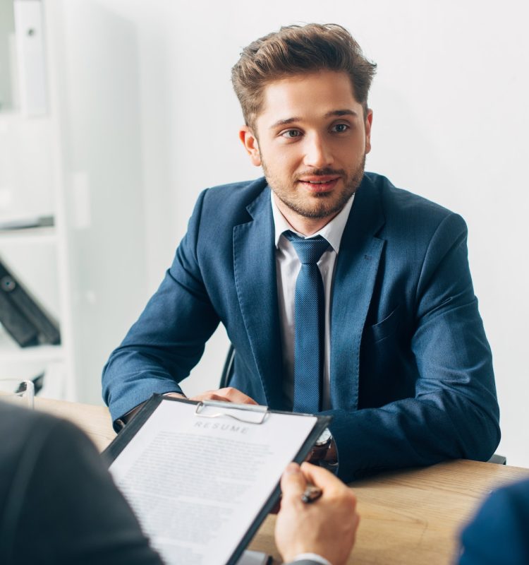 selective-focus-of-handsome-employee-looking-at-recruiter-during-job-interview.jpg interview