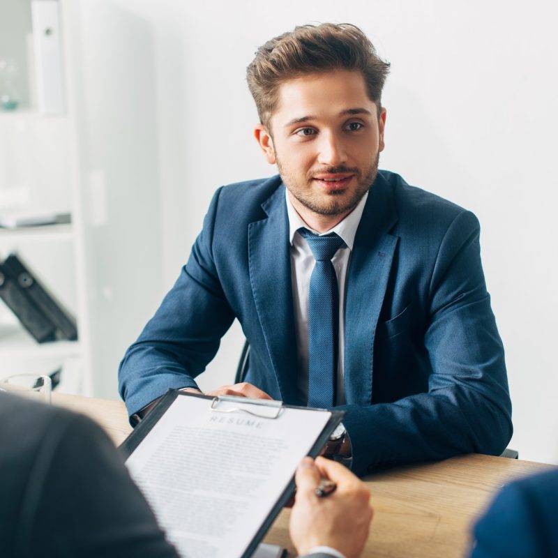 selective-focus-of-handsome-employee-looking-at-recruiter-during-job-interview.jpg interview
